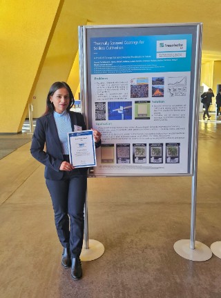 Foto der Wissenschaftlerin Pratidhwani Biswal wie sie vor ihrem Poster steht und ihre Urkunde präsentiert.